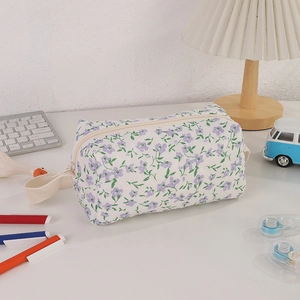 Detail of floral zipper pouch with purple flowers and a wide woven carrying strap handle