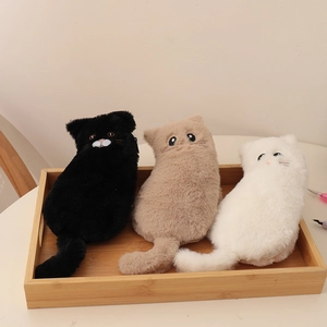 Detailed view of three plush cat pouches in black, khaki, and white on a wooden tray