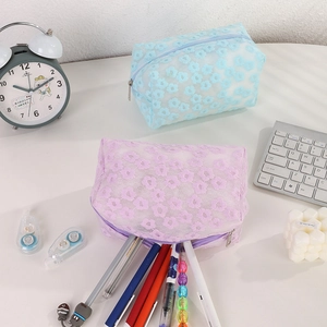 Detail showing two mesh cosmetic bags with daisy embroidery and smooth zipper closures