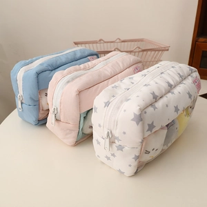 Detail view of quilted floral pencil cases in blue and pink with transparent windows