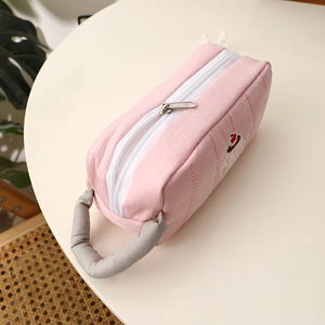 Pink quilted fabric pencil case with cute cake embroidery and a soft grey handle