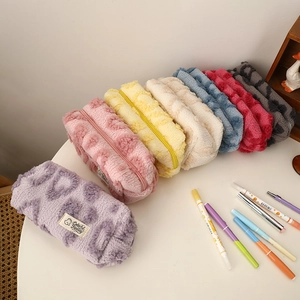 Seven colorful leopard print plush cosmetic bags shown with stationery on a desk