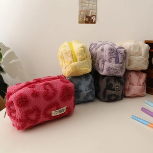 Pile of plush heart makeup bags in multiple colors with rabbit tag and top zipper