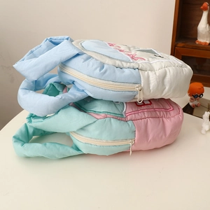 Detail of quilted makeup bags with cartoon embroidery and soft padded texture