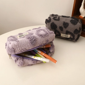 Detail view of large plush heart cosmetic bags with leopard print and zipper closure