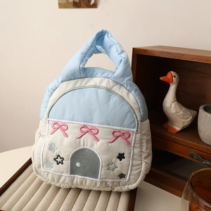 Detailed embroidery and soft quilted fabric of house-shaped blue and beige lunch bag