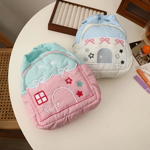 Detailed embroidery on house-shaped quilted pouches in pink and mint green tones