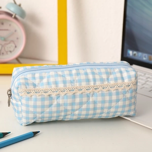 Close-up of quilted light blue plaid pencil case with elegant white lace trim detail