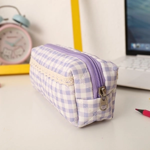 Detail of purple plaid pencil case featuring quilted texture and delicate lace trim accents