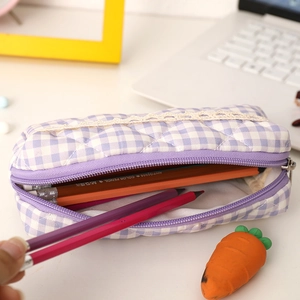 Detail of purple plaid quilted pencil case with white lace trim and colorful pencils