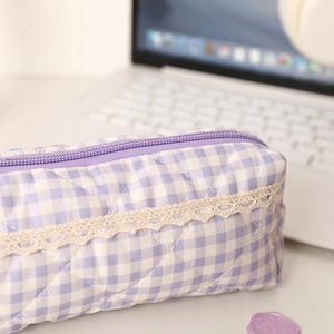 Detail of purple plaid pencil case with quilted texture and cream lace border