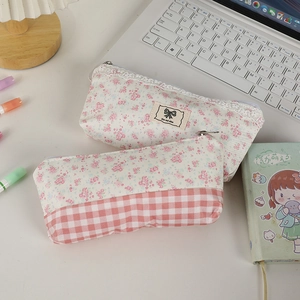 Dettaglio dell'astuccio a fiori con bordo in pizzo e design patchwork sulla scrivania