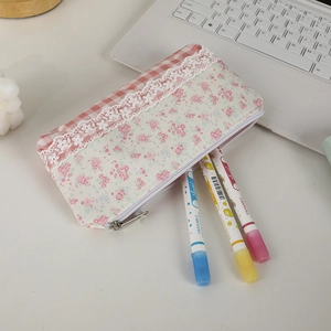 Astuccio floreale a quadretti rosa con pizzo e tre evidenziatori in scena da studio