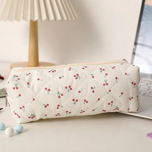 Détail d'une trousse matelassée avec imprimé cerises rouges et fermeture éclair en métal
