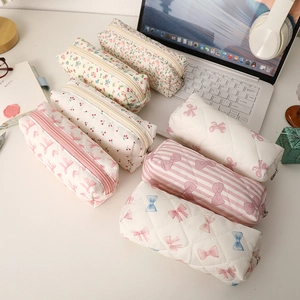 Trousses en coton avec motifs floraux et nœuds en plusieurs couleurs sur un bureau