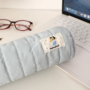 Dettaglio di un astuccio trapuntato azzurro con ricami a stella su una scrivania
