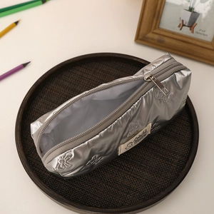 Close-up of quilted silver pencil case with metallic finish and colorful fantasy label