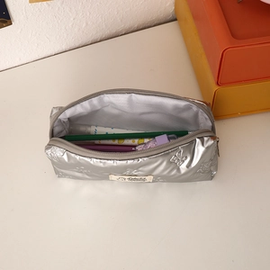 Detailed view of silver bow-embossed pencil case with large capacity and zip closure