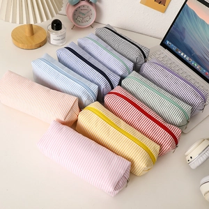 Large capacity striped seersucker pencil cases in various colors on a tidy office desk
