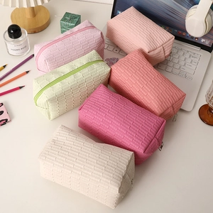 Quilted cosmetic bags in 6 pastel colors with top zipper and woven texture details