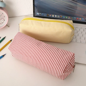 Seersucker striped pencil cases in red and yellow with metal zipper on desk