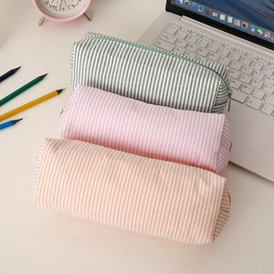 Close-up of striped seersucker pencil cases in green, pink and orange colors