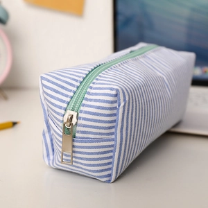 Detail of seersucker pencil case showing blue striped fabric and mint green zipper texture