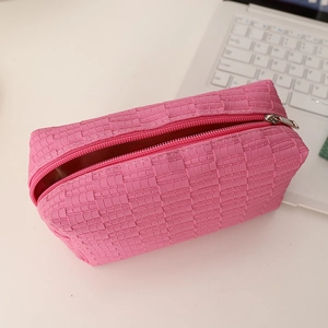 Detailed view of pink woven texture cosmetic bag with zipper and grid pattern