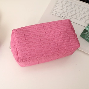 Macro view of the pink woven texture and zipper on this large cosmetic storage bag