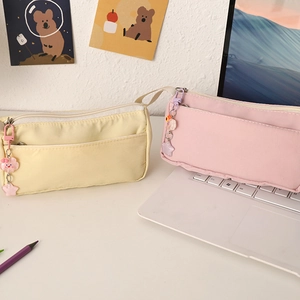 Detail of layered zippers on yellow and pink pencil bags with cute cloud charms