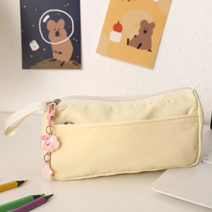 Detail of yellow canvas pencil pouch with pink cloud charm and front storage pocket