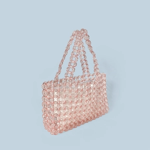 Detail of pink crystal bead weave handbag with white inner lining on blue background