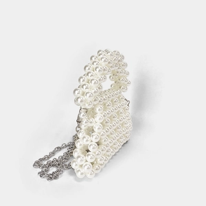 Détail d'un sac à main en perles blanches avec une bandoulière amovible en chaîne argentée
