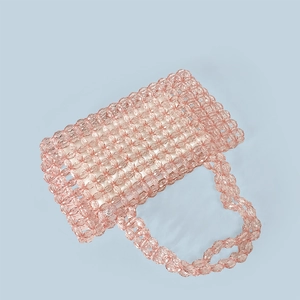 Macro shot of pink transparent beaded handbag with geometric grid texture and beaded handles