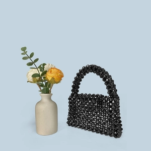 Detailed view of a black handmade beaded handbag with shiny multifaceted acrylic beads