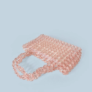 Top view of handmade pink crystal beaded handbag showing intricate floral weaving texture