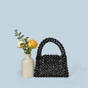 Detailed close-up of a black acrylic beaded mini tote bag with an elegant handle