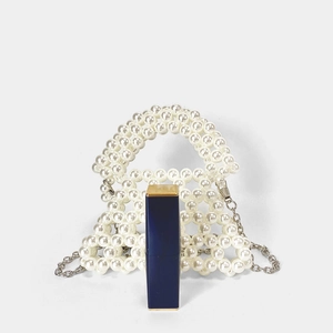 Détail du mini sac trapèze en perles blanches fait main avec une chaîne en métal argenté