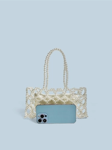 Sac à main fait main en perles avec doublure en satin et poignées tissées sur fond bleu