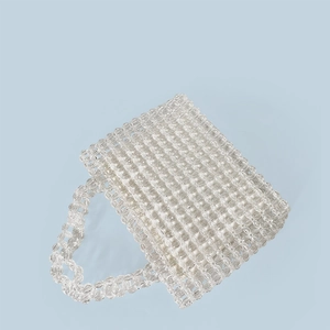 Detailed close-up of handmade clear acrylic bead weaving on a transparent tote handbag