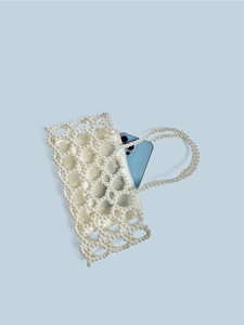 Sac à main artisanal en perles avec doublure en soie et bandoulière sur fond bleu
