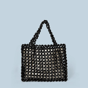 Detail of handmade black beaded tote bag featuring intricate floral woven patterns