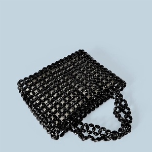 Detail of hand-woven black acrylic beaded tote bag showing shiny faceted beads and texture