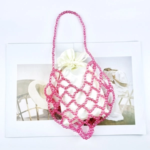 Close-up of pink beaded crochet bag with transparent beads and white satin drawstring liner