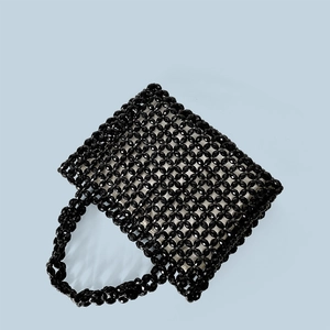 Detail of hand-woven black acrylic beaded bag showing intricate diamond mesh texture