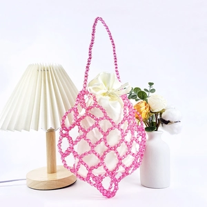 Detail of pink beaded woven handbag with white satin drawstring inner pouch and mesh design