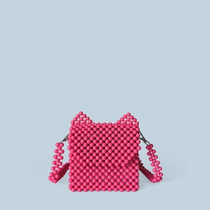 Détail du sac à main en perles rose fait main avec oreilles de chat sur fond bleu