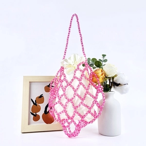 Detail of pink beaded handbag with hollow mesh design and white satin drawstring inner bag