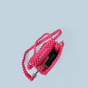 Détails de l'intérieur du sac en perles roses montrant l'espace pour le rouge à lèvres