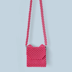 Vue détaillée du sac à bandoulière rose perlé avec design oreilles de chat et bandoulière